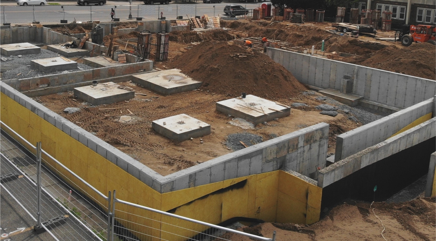 A construction site with concrete footings underway.
