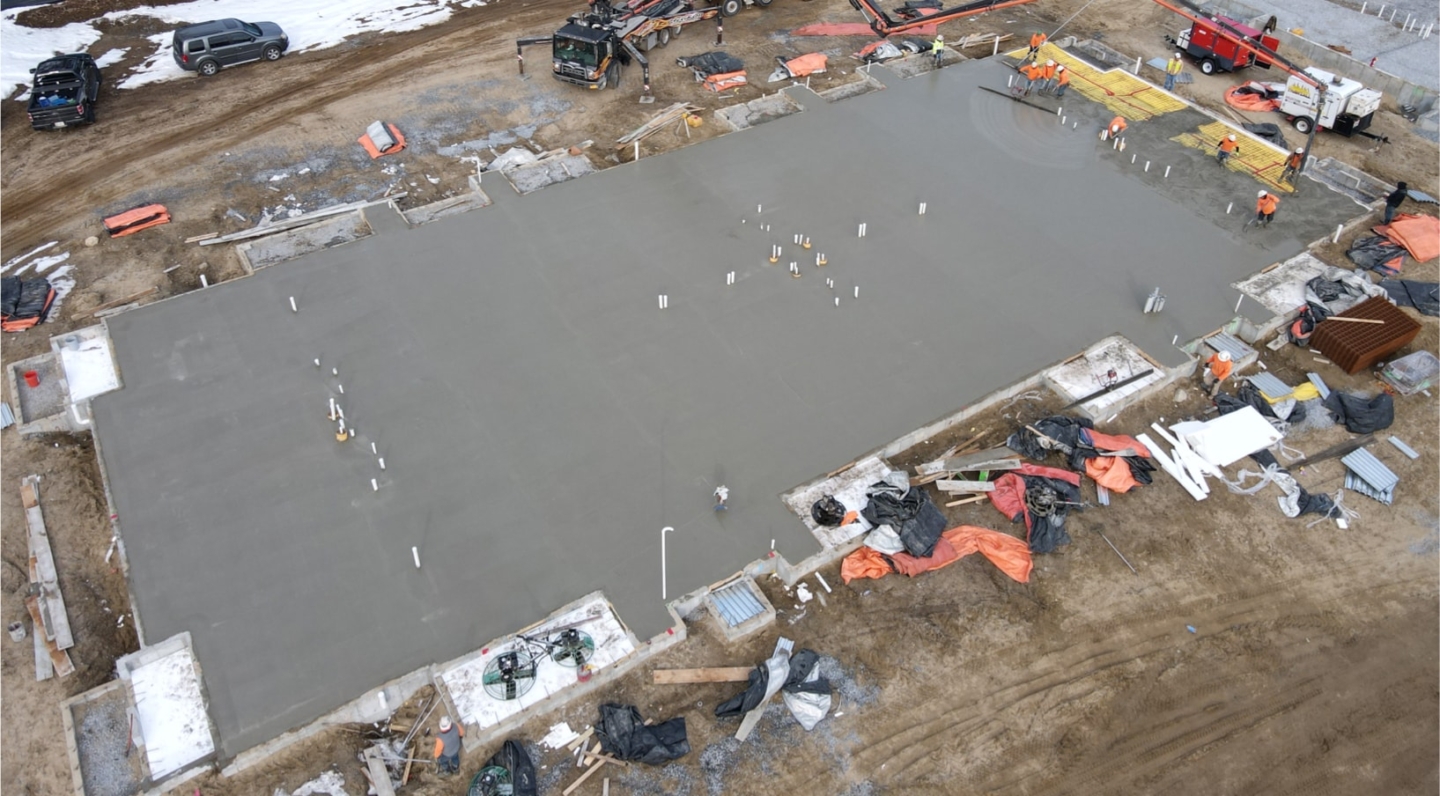 Aerial view of a freshly poured concrete slab on grade.